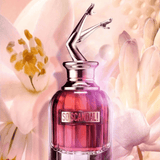 Jean Paul Gaultier So Scandal! Eau de Parfum 80ml surrounded by white floral notes, highlighting its feminine and seductive fragrance profile.